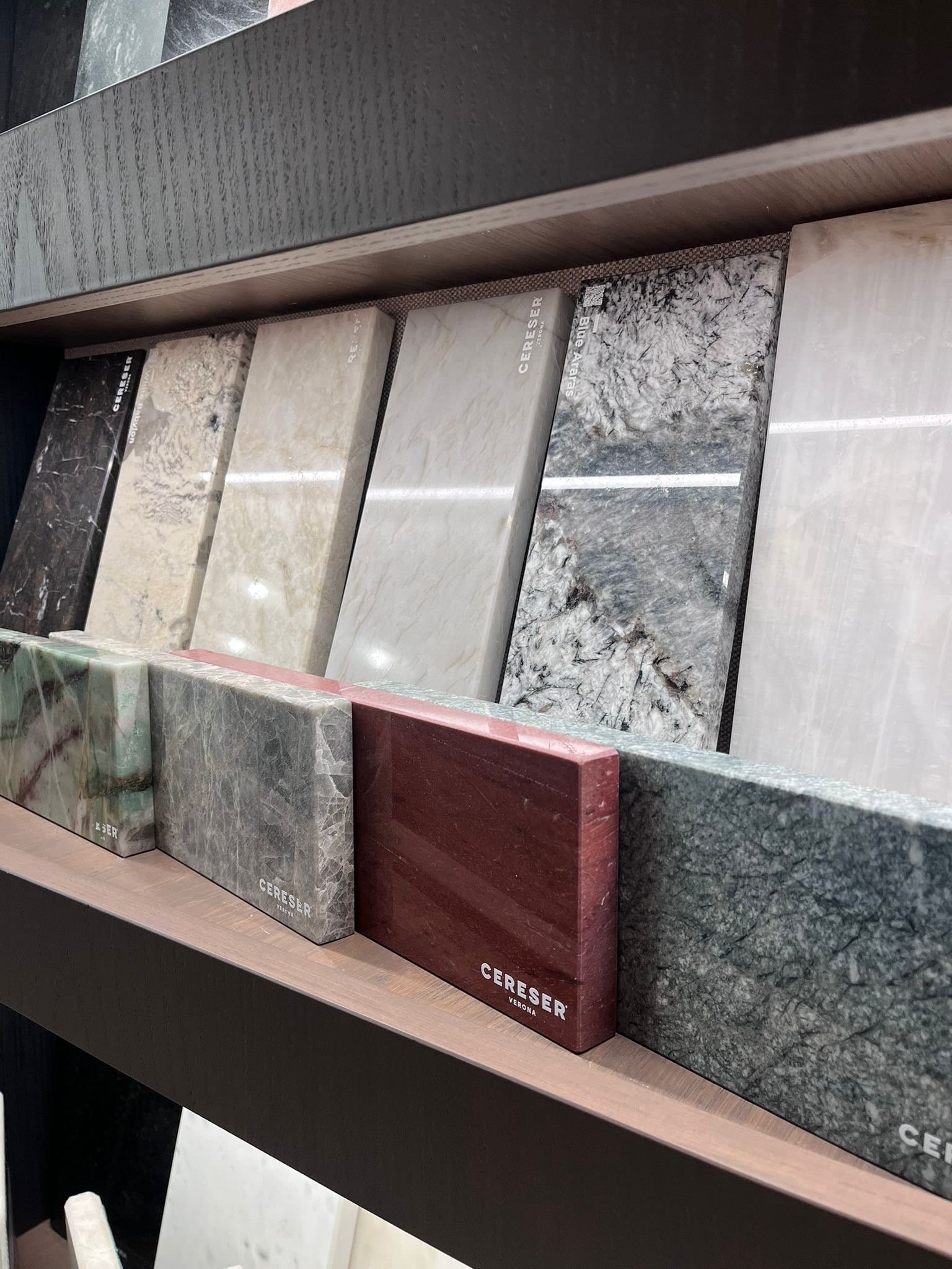 Płyty wielkoformatowe różnych kolekcji oparte o ścianę showroomu